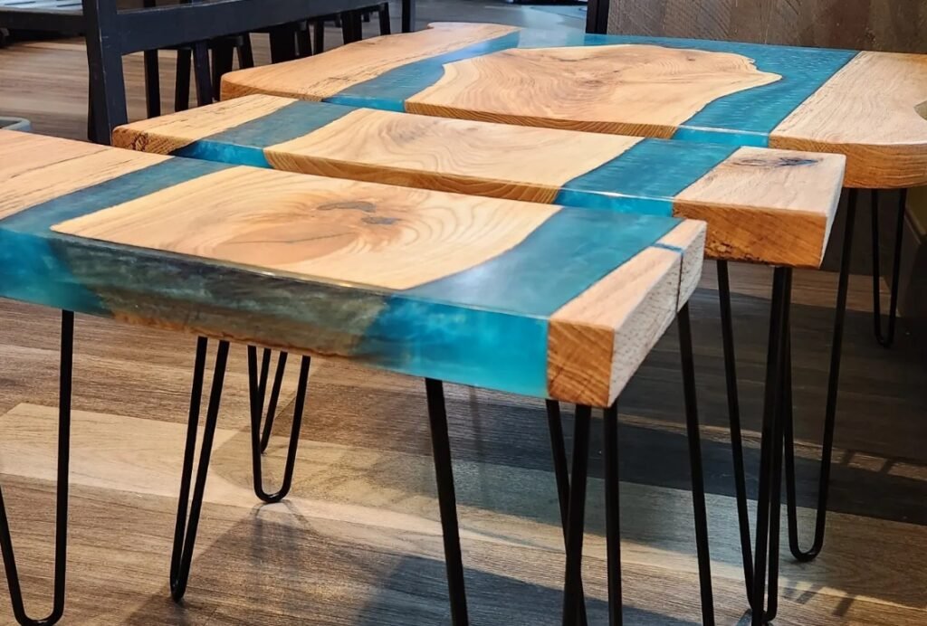 Three live edge hardwood side tables with bright blue epoxy river inlays and black hairpin legs